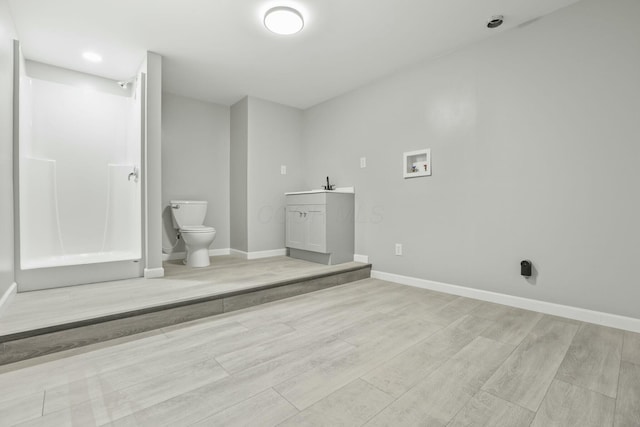 clothes washing area with sink, hookup for a washing machine, and light hardwood / wood-style flooring