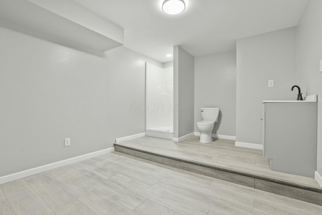 bathroom featuring sink, hardwood / wood-style floors, and toilet