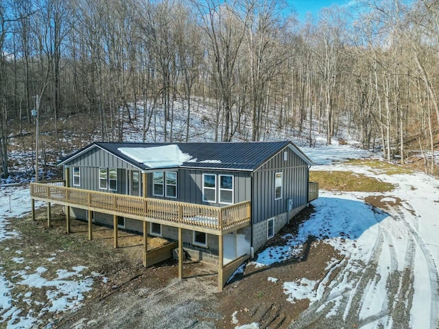 snow covered house with a wooden deck