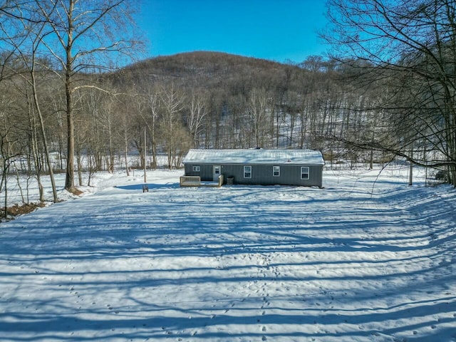 yard covered in snow featuring a mountain view