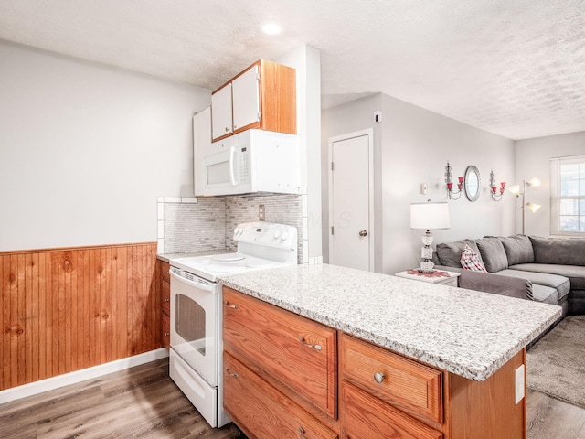 kitchen featuring dark hardwood / wood-style flooring, a textured ceiling, white appliances, and kitchen peninsula