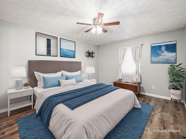 bedroom with ceiling fan, a textured ceiling, and dark hardwood / wood-style flooring