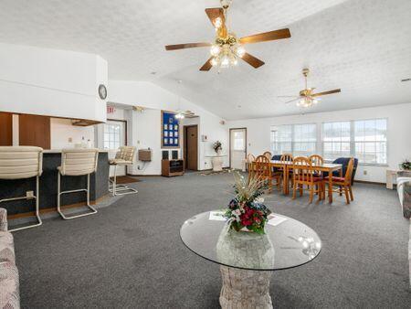 carpeted dining room with lofted ceiling, ceiling fan, and a textured ceiling