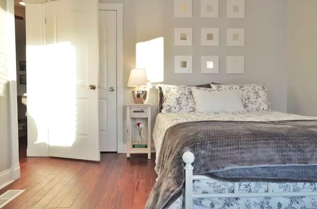 bedroom with dark hardwood / wood-style flooring