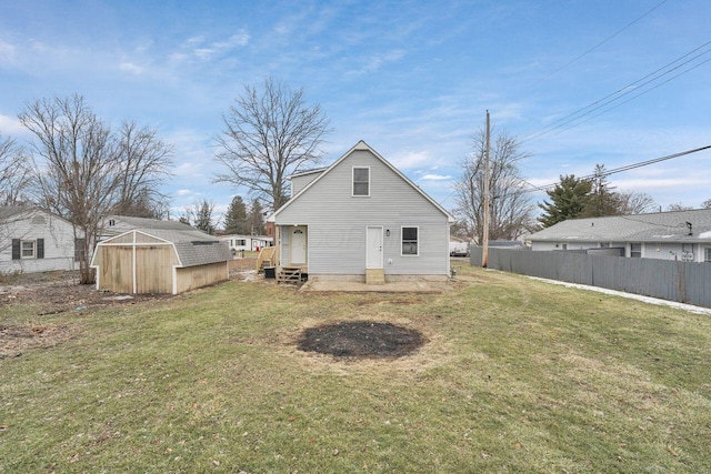 rear view of house featuring a yard and a storage unit