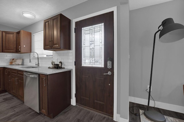 kitchen with sink, decorative backsplash, dark wood-type flooring, and stainless steel dishwasher