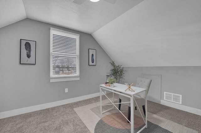 carpeted office space with ceiling fan and vaulted ceiling