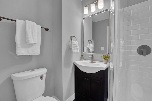 bathroom featuring vanity, tiled shower, and toilet