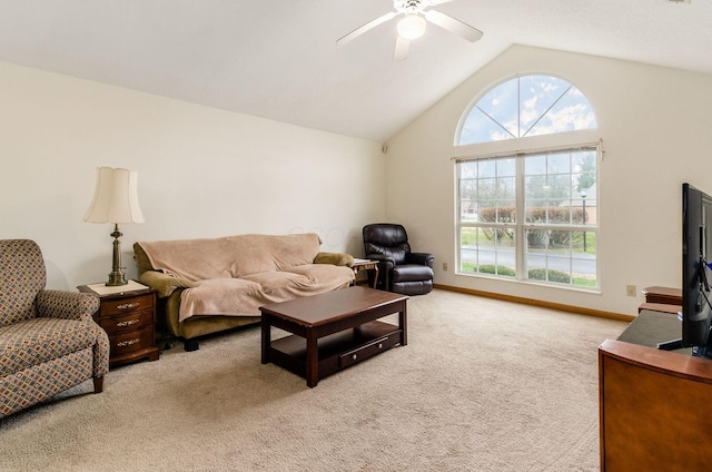 carpeted living room with ceiling fan and high vaulted ceiling