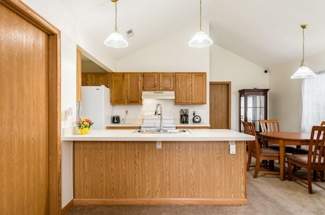 kitchen featuring white refrigerator, decorative light fixtures, and sink