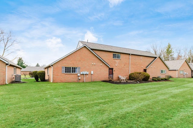 back of house with cooling unit and a yard