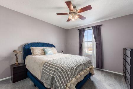 bedroom featuring dark colored carpet and ceiling fan