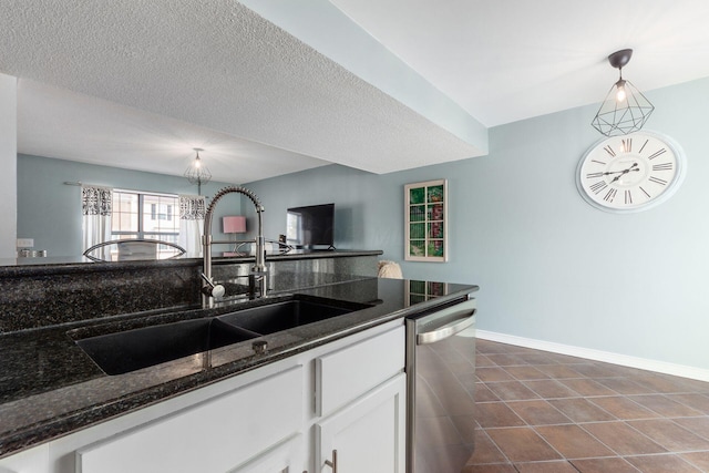 kitchen featuring sink, dishwasher, dark stone countertops, hanging light fixtures, and white cabinets