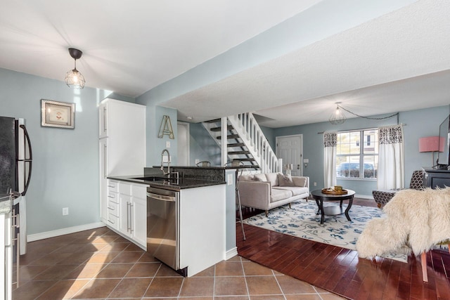 kitchen with sink, white cabinetry, kitchen peninsula, dishwasher, and dark tile patterned flooring