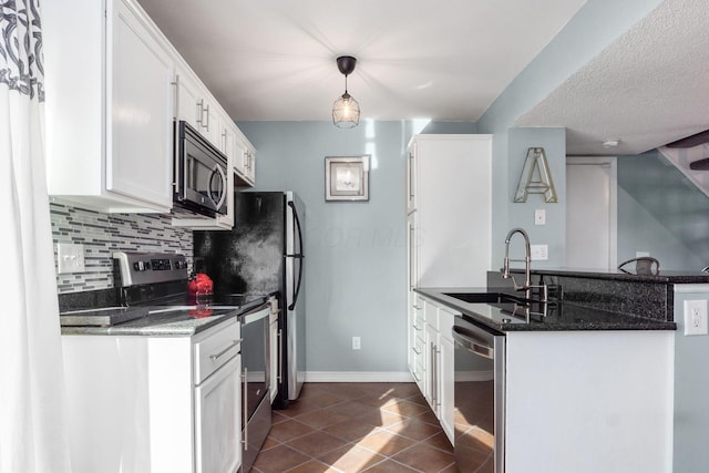 kitchen with sink, backsplash, stainless steel appliances, white cabinets, and decorative light fixtures