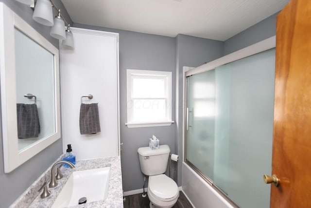 full bathroom with vanity, enclosed tub / shower combo, and toilet