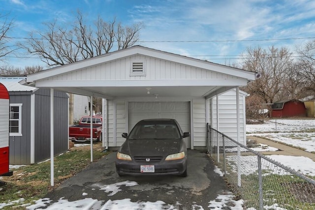 snow covered parking with a garage