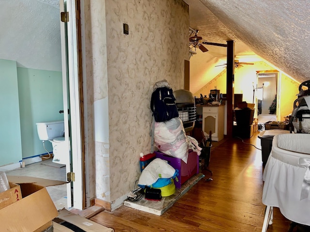 interior space with ceiling fan, wood-type flooring, and a textured ceiling