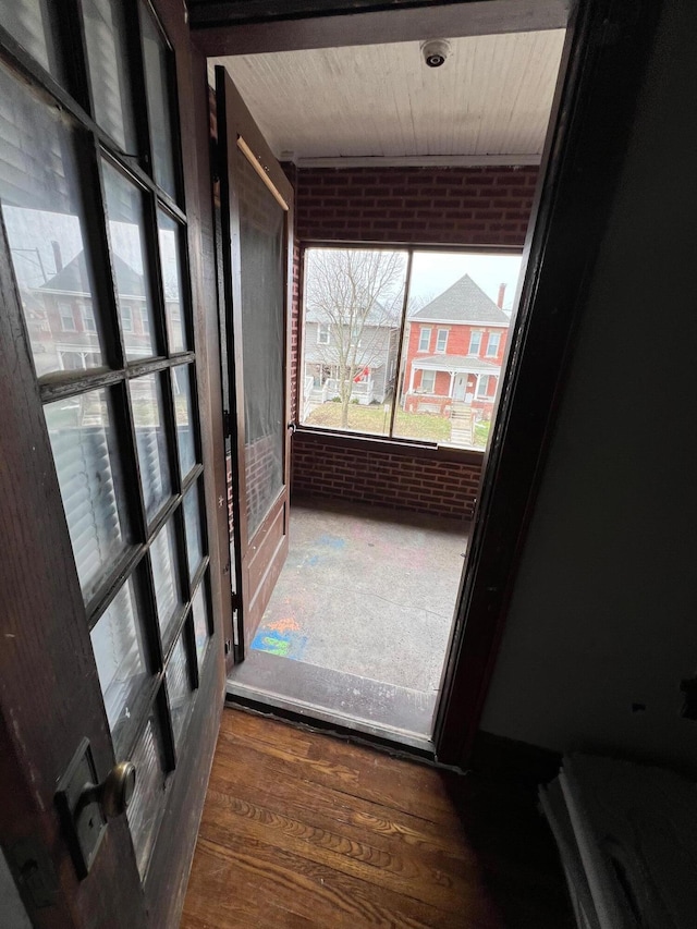 interior space featuring brick wall and dark hardwood / wood-style flooring