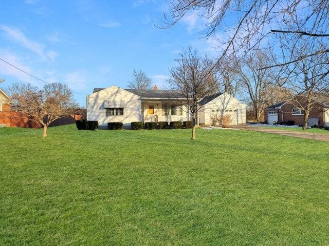 ranch-style house with a garage and a front lawn