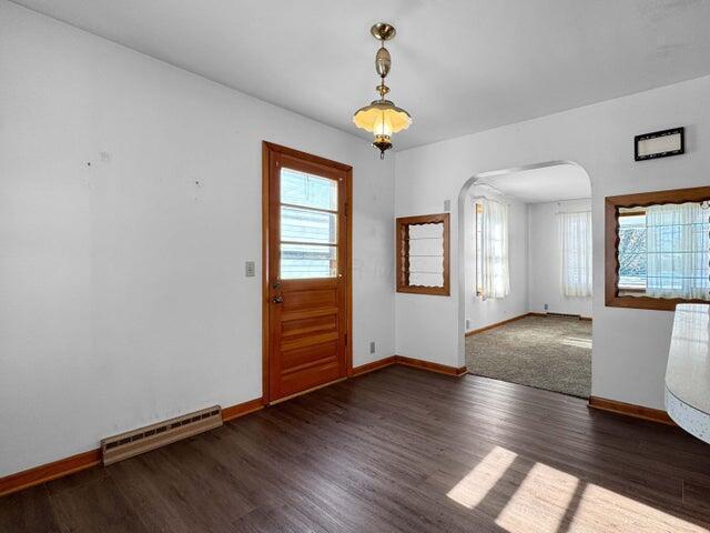 foyer entrance featuring dark wood-type flooring and a baseboard radiator