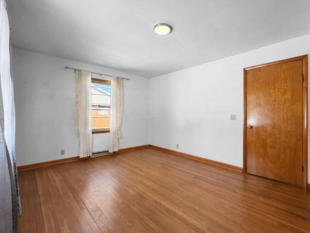 spare room with hardwood / wood-style flooring