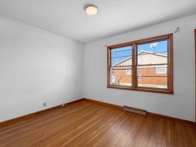 spare room featuring wood-type flooring