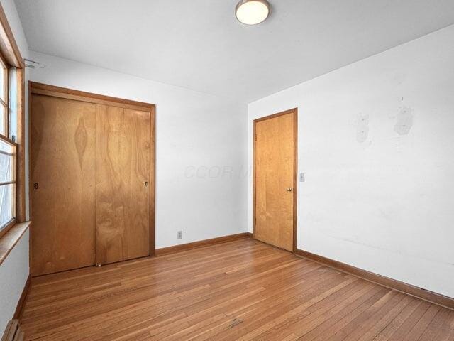 unfurnished bedroom with a closet and light hardwood / wood-style flooring