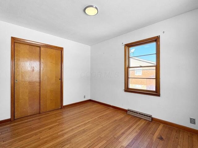 unfurnished bedroom featuring light hardwood / wood-style floors and a closet