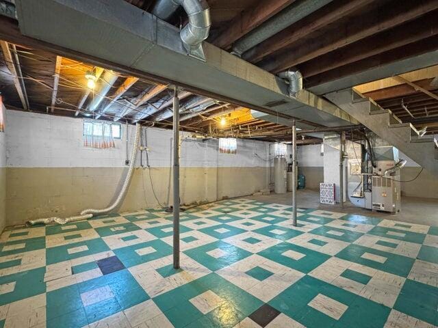 basement featuring heating unit and water heater