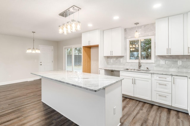 kitchen featuring sink, decorative light fixtures, and white cabinets