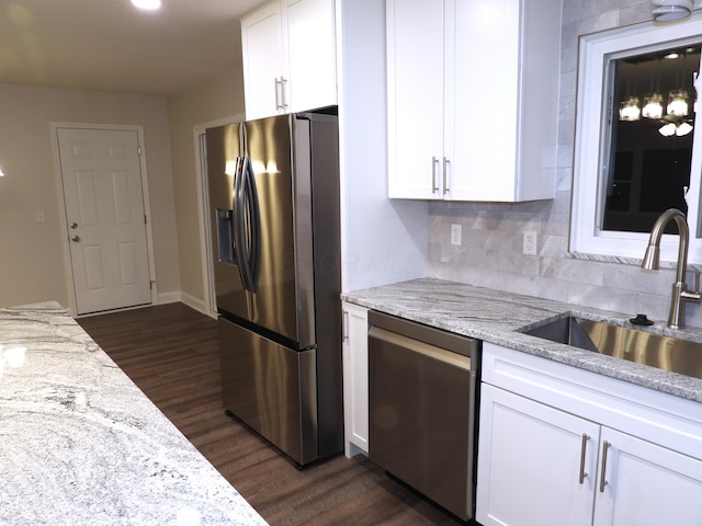 kitchen with sink, light stone counters, dark hardwood / wood-style floors, stainless steel appliances, and white cabinets