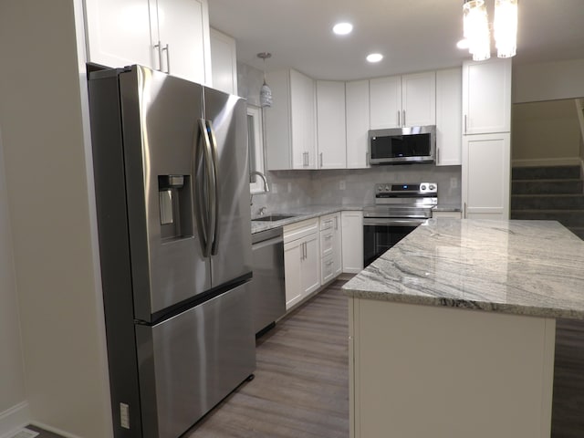 kitchen featuring pendant lighting, stainless steel appliances, and white cabinets