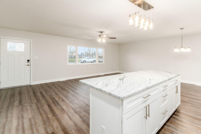 kitchen featuring pendant lighting, dark wood-type flooring, white cabinets, and a kitchen island