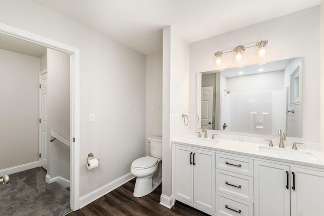 bathroom featuring vanity, a shower, wood-type flooring, and toilet