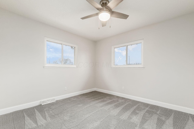 empty room featuring ceiling fan and carpet