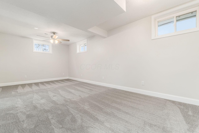 basement with ceiling fan, carpet, and a textured ceiling