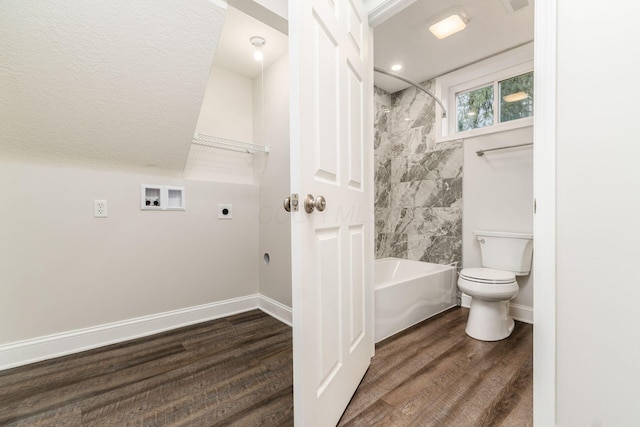 bathroom with tiled shower / bath combo, wood-type flooring, and toilet