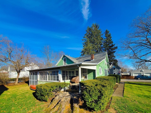 view of front of house with a sunroom and a front lawn