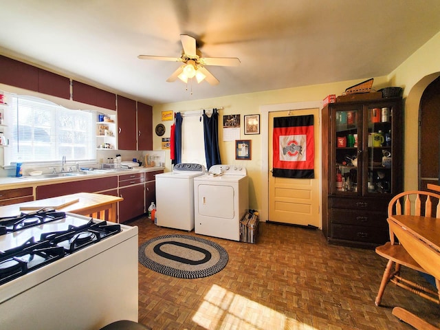 kitchen featuring sink, ceiling fan, independent washer and dryer, dark parquet floors, and white range with gas cooktop