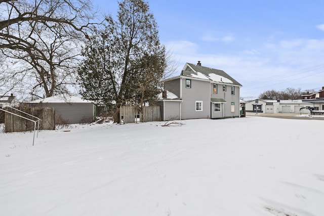 view of snow covered rear of property