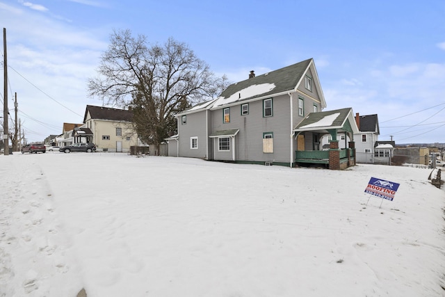 view of snow covered back of property