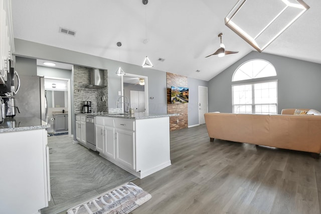 kitchen featuring hanging light fixtures, appliances with stainless steel finishes, a ceiling fan, open floor plan, and white cabinetry