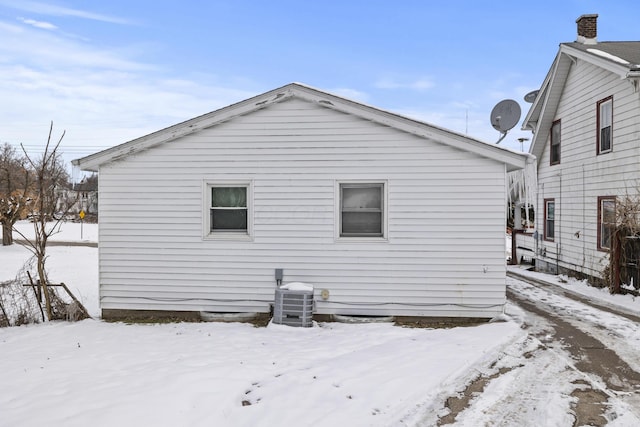 snow covered property featuring central AC unit