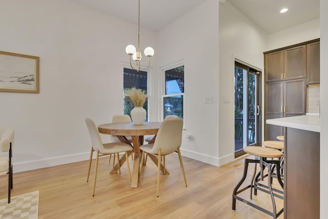 dining space featuring an inviting chandelier, a wealth of natural light, and light wood-type flooring