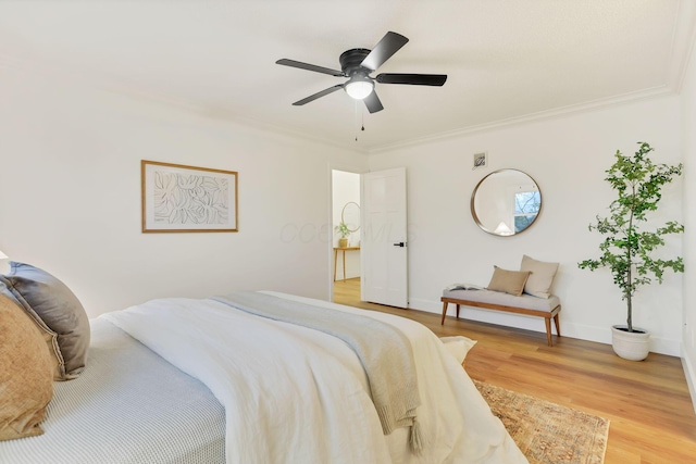 bedroom featuring hardwood / wood-style floors, crown molding, and ceiling fan