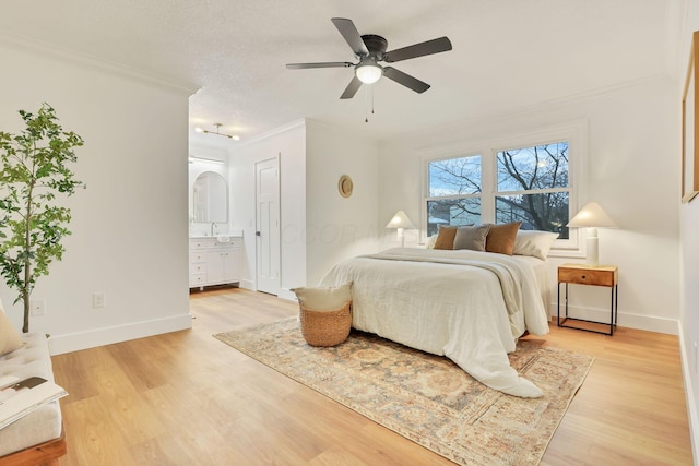 bedroom featuring crown molding, ensuite bathroom, a textured ceiling, and light wood-type flooring