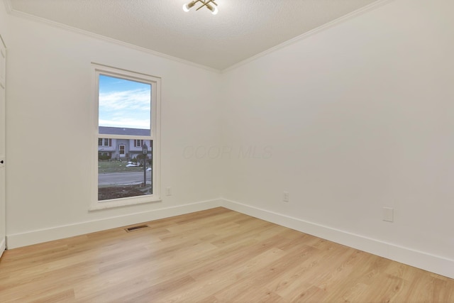 unfurnished room with crown molding, a textured ceiling, and light wood-type flooring