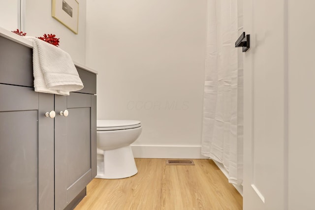 bathroom with vanity, wood-type flooring, and toilet