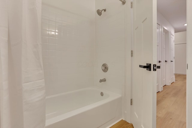 bathroom featuring hardwood / wood-style floors and shower / bath combo with shower curtain